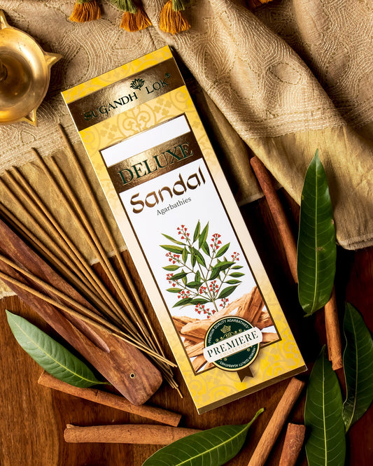 Deluxe Sandal Agarbatti Pack surrounded by sandalwood and leaves
