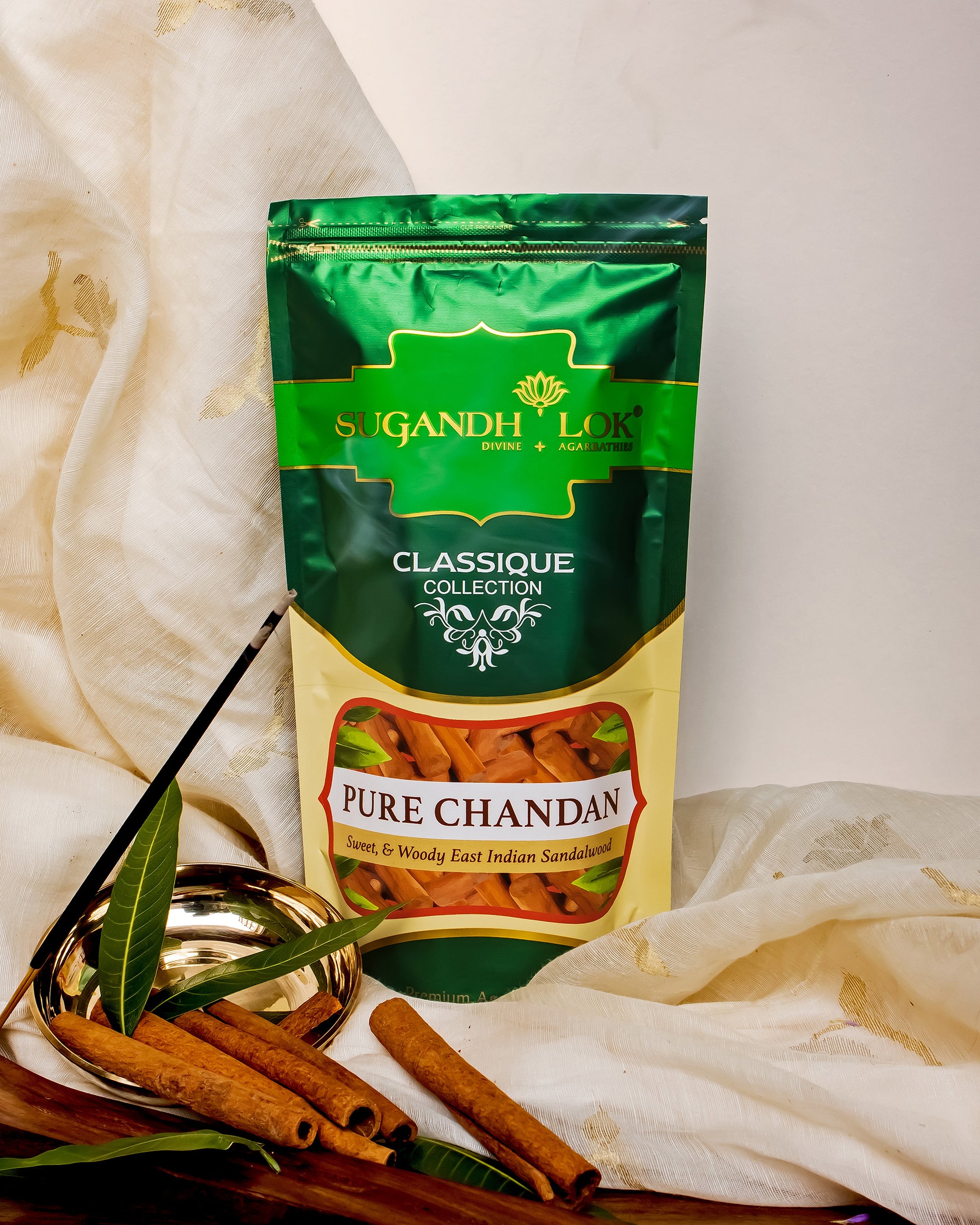 Pure Chandan Agarbatti Pouch placed on table surrounded by chandan sticks and leaves