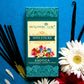 Front of Exotica Agarbatti Mini Sticks Pack surrounded by flowers and incense sticks